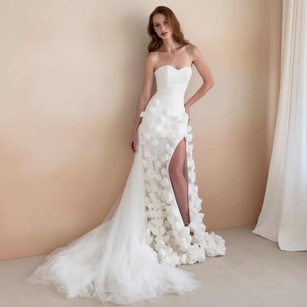 Gorgeous Woman in a white strapless couture wedding gown with floral details standing in front of a scenic painting.