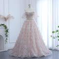 Stunning couture luxury Pink evening gown with beautiful silver embellishments on a mannequin against a white curtain background.
