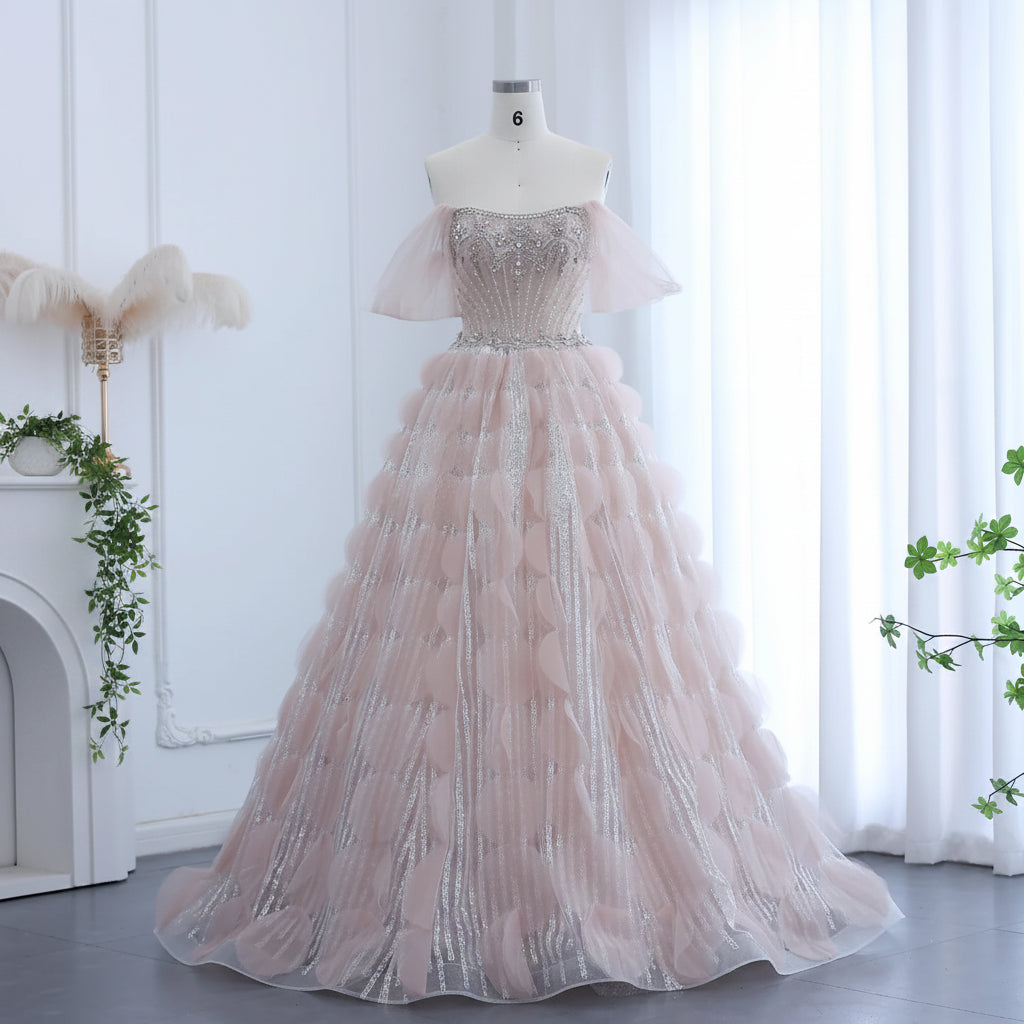 Stunning couture luxury Pink evening gown with beautiful silver embellishments on a mannequin against a white curtain background.