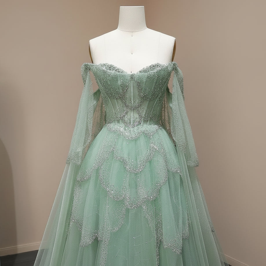 Mint green evening gown with intricate beaded crystal detailing on a mannequin against a light background