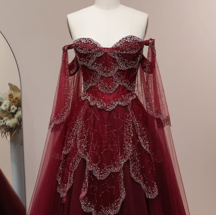 Red evening gown with intricate detailing on a mannequin against a light background