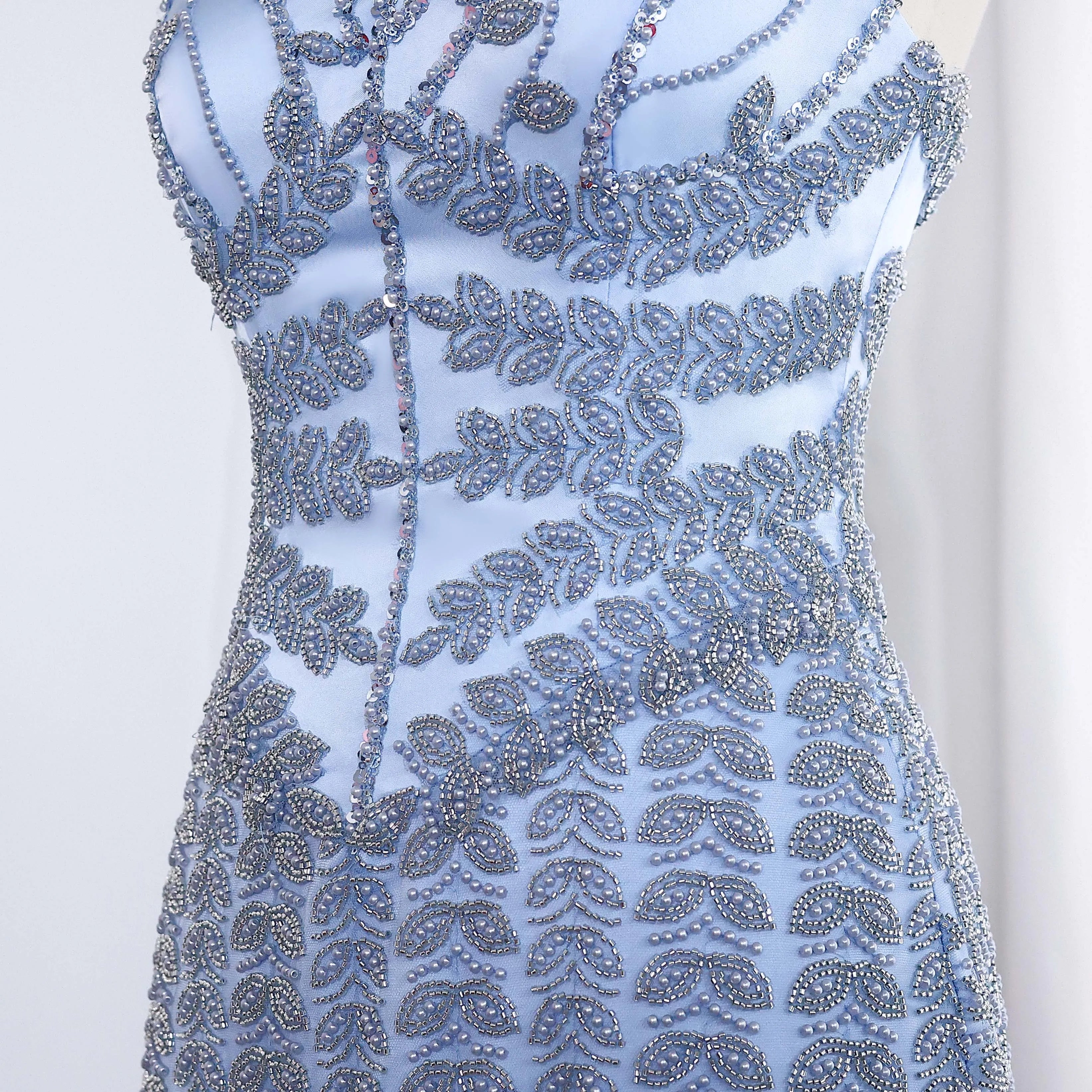 Beautiful light Blue couture inspired beaded dress with intricate silver patterns on a white background