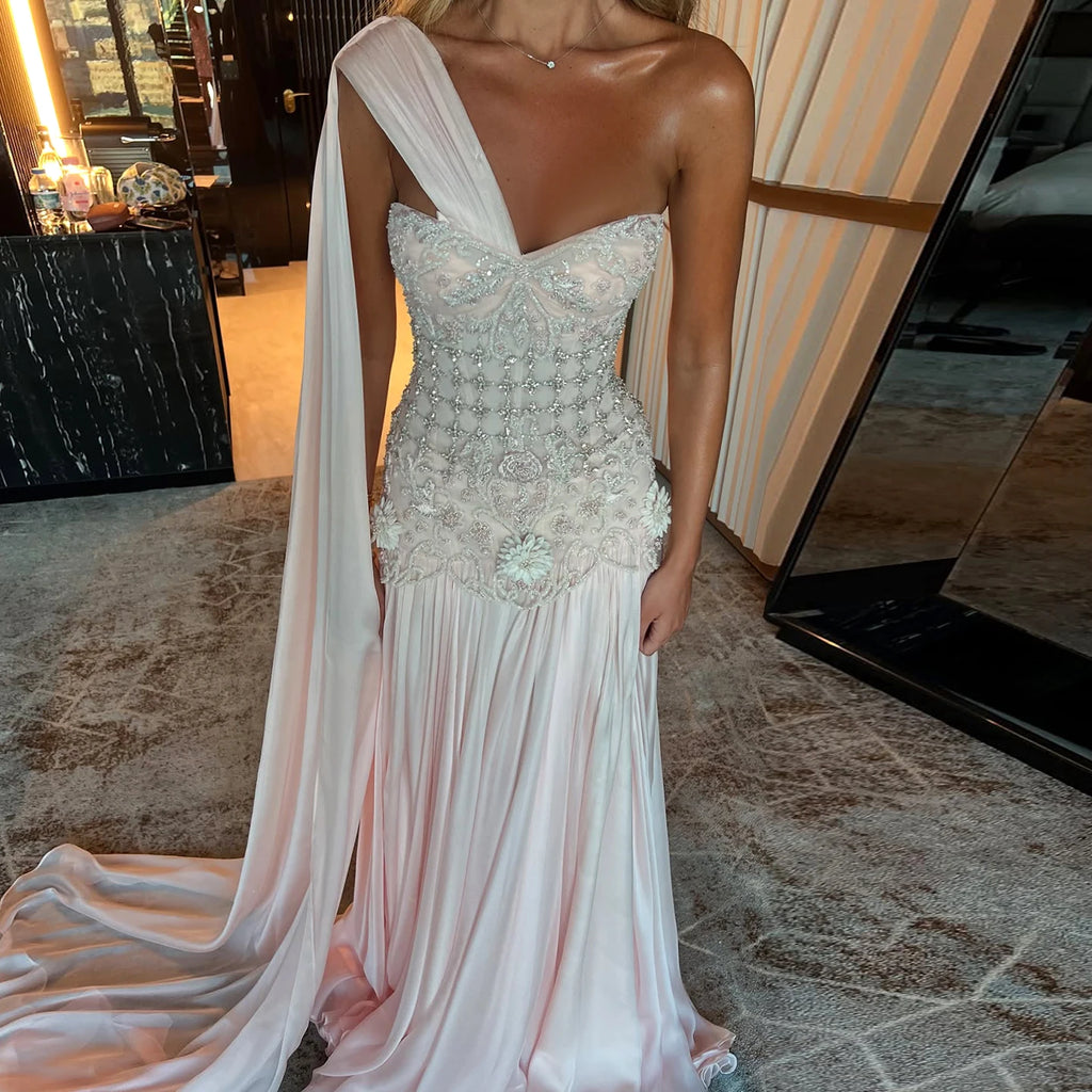 Stunning couture fashion white elegant evening gown with a cape in an indoor setting