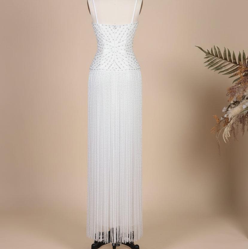 Gorgeous White evening gown with crystal embellishments and fringe details on a mannequin against a neutral background