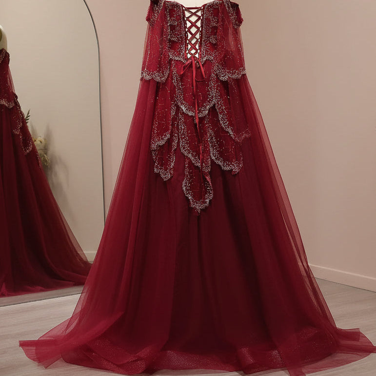 Beautiful Red evening gown with intricate lace and crystal beading detailing on a mannequin against a light background