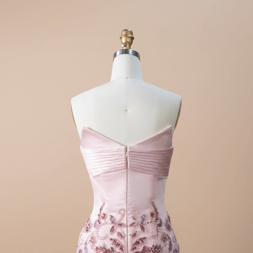 Mannequin wearing an elegant beautiful pink satin dress with floral beaded details on a beige background