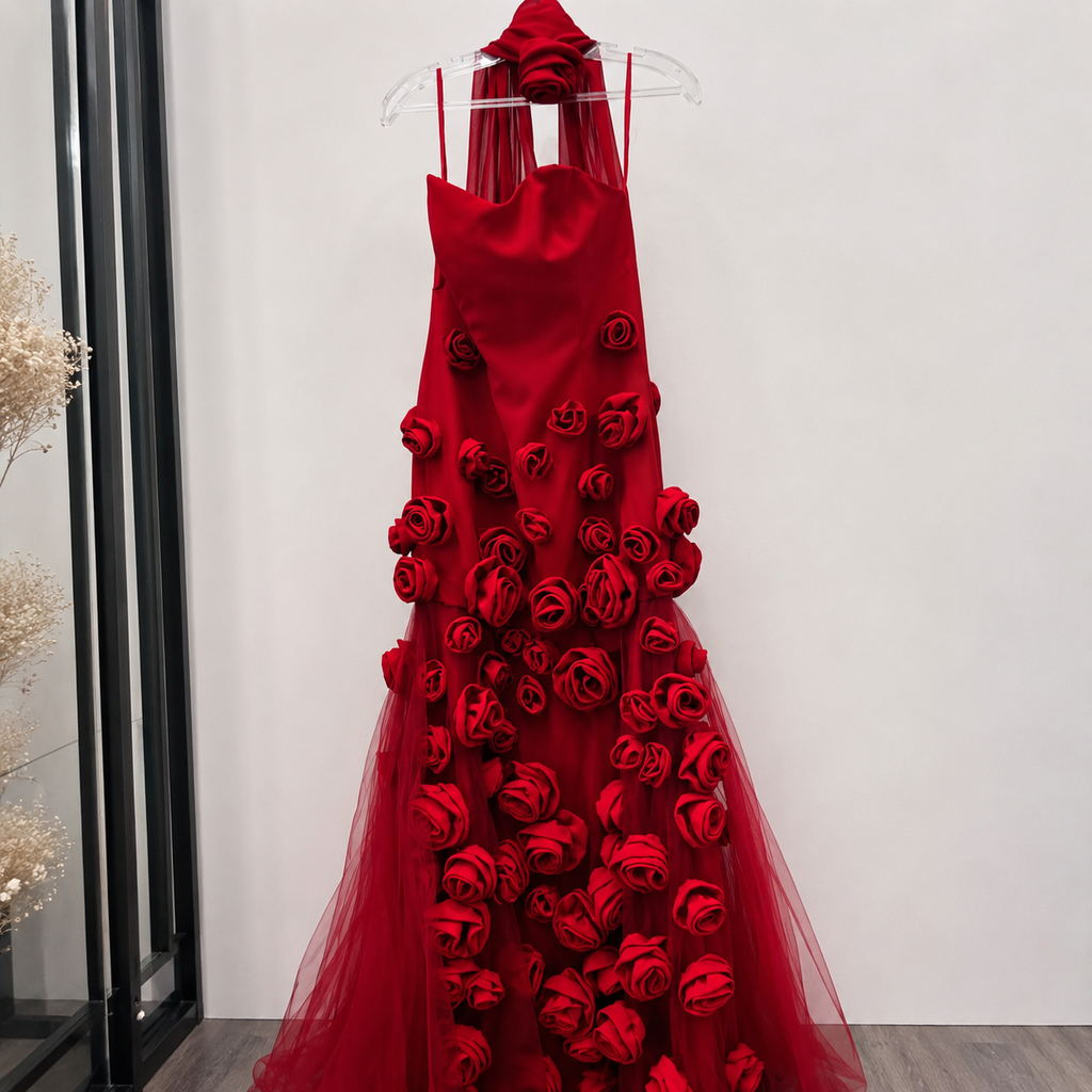 Stunning Red evening dress with couture inspired red rose details on a hanger against a white wall.