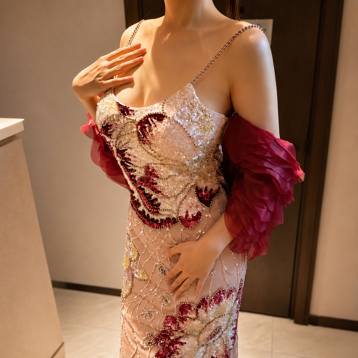 Beautiful woman wearing an elegant luxury pink intricately beaded with shiny crystals in floral designs