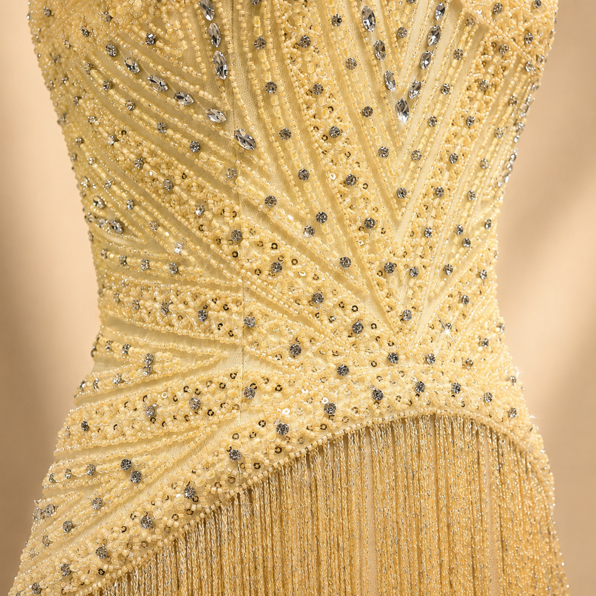 Yellow Gold rhinestone crystal embellishment luxury fashion beaded dress with fringe detail on a beige background