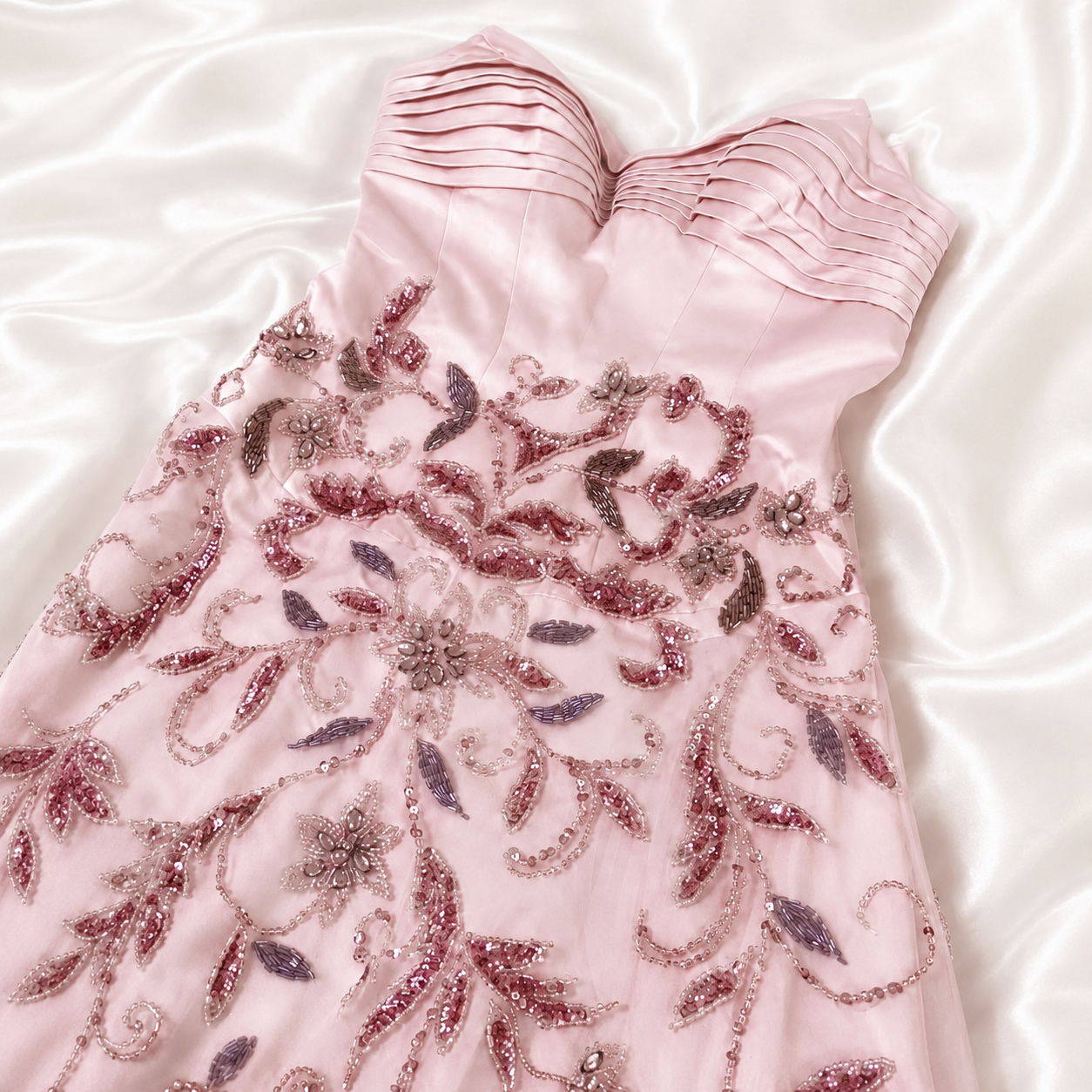 Luxury Pink evening gown with stunning crystal floral beading on a white fabric background