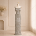 Elegant sage green evening gown dress with luxury details of intricate silver embellishments on a mannequin in bright lighting