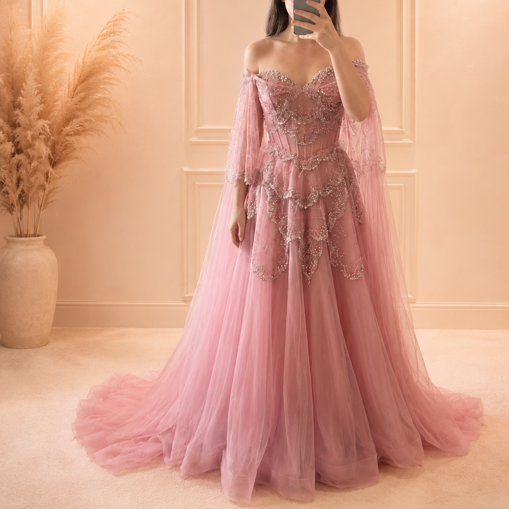 Beautiful Lady wearing a pink princess inspired luxury ballgown with sparkling embellishments in a softly lit room.