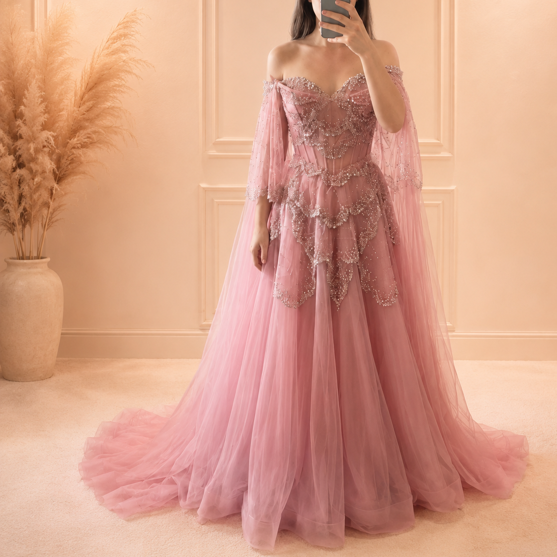 Beautiful Lady wearing a pink princess inspired luxury ballgown with sparkling embellishments in a softly lit room.