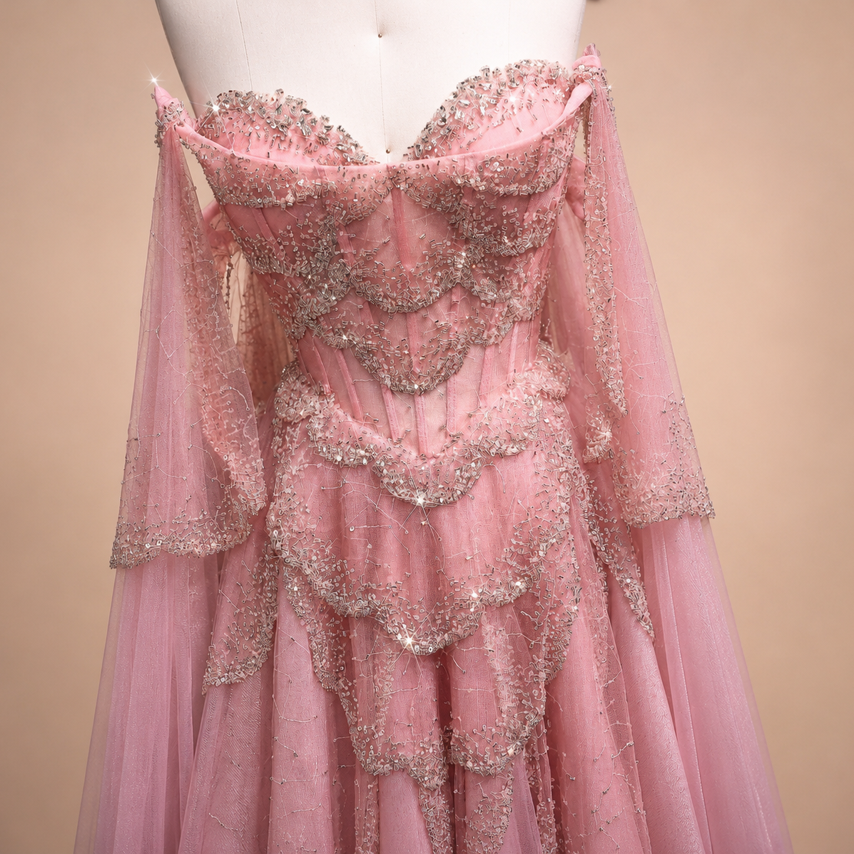 Gorgeous Pink evening ballgown with intricate sparkling beading on a mannequin against a beige background