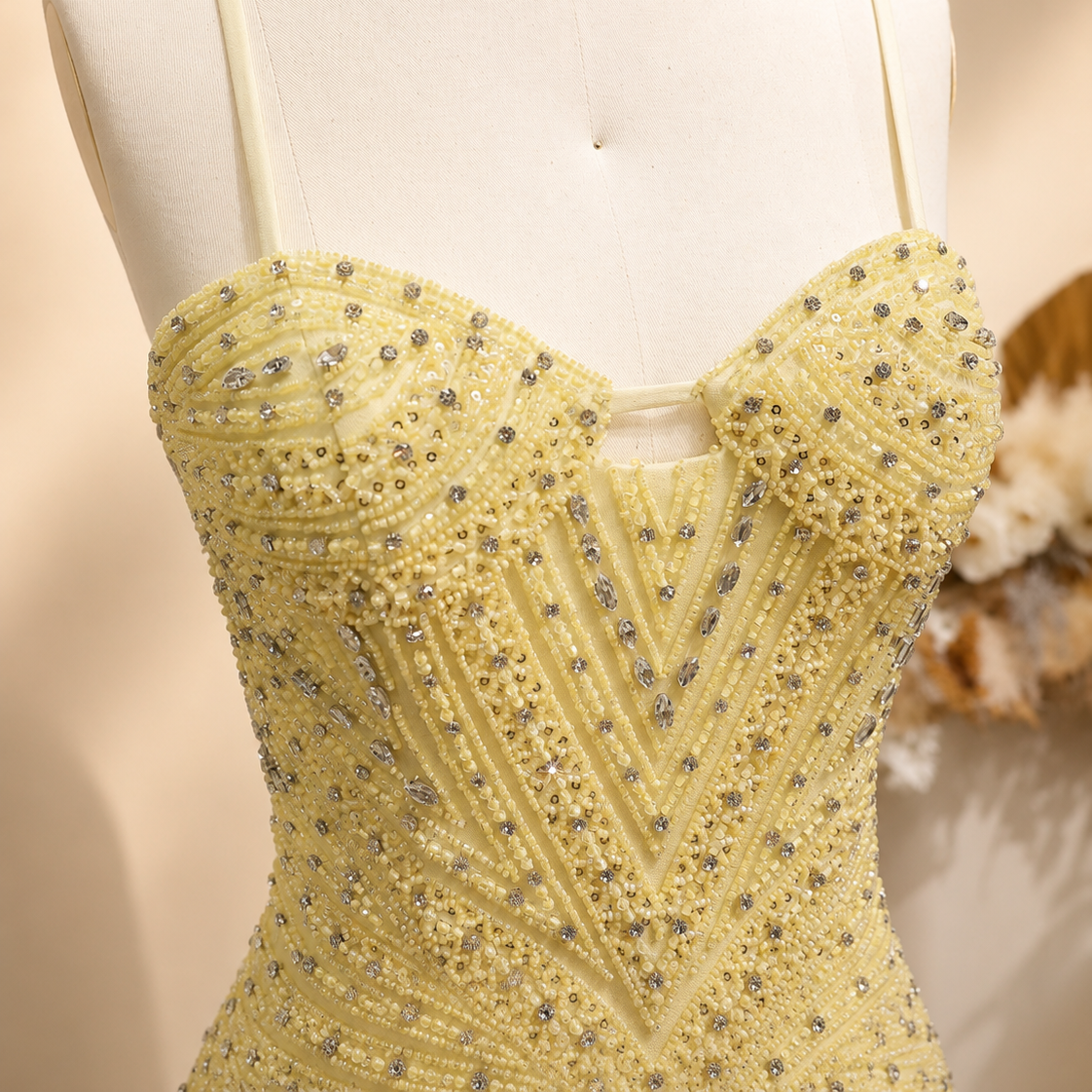 Beautiful Yellow beaded evening gown on a mannequin against a neutral background